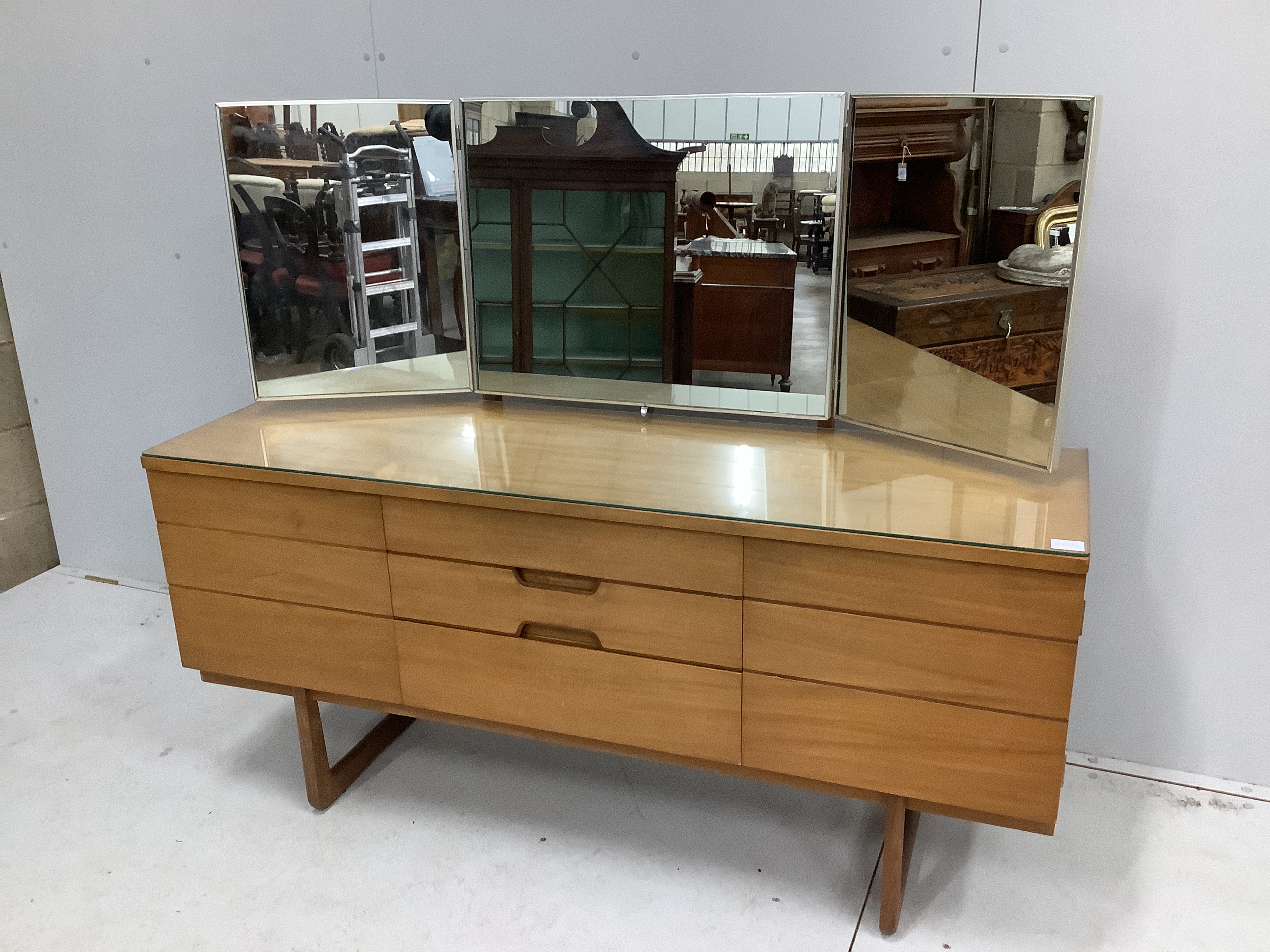 A mid century Uniflex teak dressing table with triple mirrored back, width 152cm, depth 46cm, height 128cm